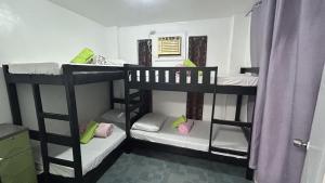 a room with three bunk beds in a room at Anabelle Residence in Dumaguete