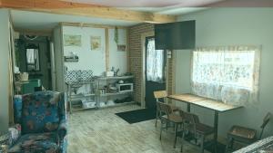 a living room with a kitchen with a table and chairs at Geraldton Rooms in Geraldton
