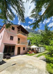 a pink house with a balcony on the side of it at Arditi's Villa in Shkodër