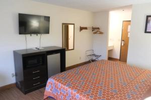 a bedroom with a bed and a flat screen tv at FairBridge Inn Express Chesterton in Chesterton