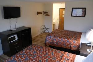 a hotel room with two beds and a flat screen tv at FairBridge Inn Express Chesterton in Chesterton