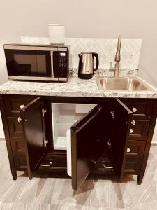 a kitchen counter with a microwave and a sink at Casa Luque in Culiacán
