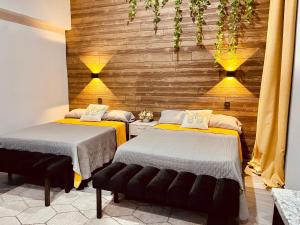 two beds in a room with wooden walls at Casa Luque in Culiacán