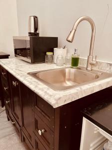 a kitchen counter with a sink and a microwave at Casa Luque in Culiacán +14 photos