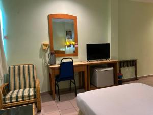 a bedroom with a desk with a computer and a mirror at Hotel City Star in Sandakan +16 photos