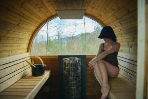 a woman is sitting in a sauna at Ember Resort AZUMIMO 静寂の森に佇むプライベートサウナ付き一棟貸しリトリート in Azumino