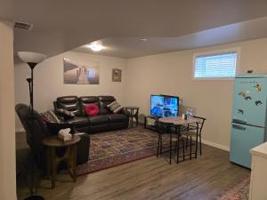 a living room with a leather couch and a table at The Peaceful Lower Loft in Winnipeg