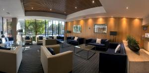a lobby with couches and chairs in a building at Hotel Stella Maris in Mexico City