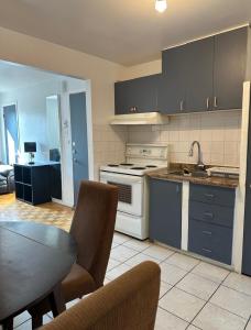 a kitchen with a stove and a table in a room at Hotel Mini Inc in Montreal