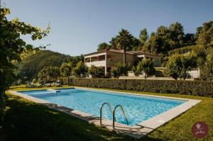 a swimming pool in front of a house at Casa da Adega - Quinta da Portela in Terras de Bouro