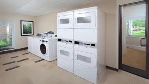 a white laundry room with a washer and dryer at Candlewood Suites Kenedy by IHG in Kenedy +21 photos