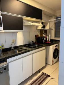 a kitchen with a sink and a washing machine at Apartamento com 02 quartos in Maceió