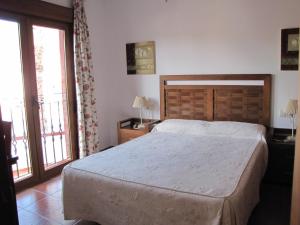 a bedroom with a large bed and two windows at Hotel-Apartamento Carolina y Vanessa in San José