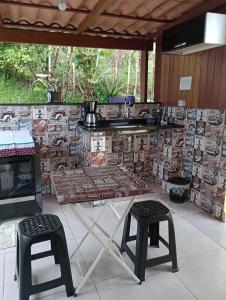 a kitchen with a counter and two stools and a table at Alta Vista in Penedo