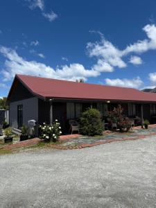 a building with a red roof on a street at #5 Glenorchy Alpine Suite in Glenorchy