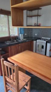a kitchen with a wooden table and a stove at La Casita del Monte in San Miguel del Monte