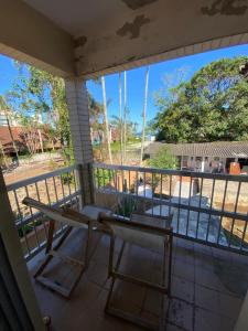 a balcony with a bench and a table and chairs at Sool Beach Hostel in Bertioga