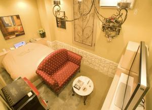a room with a bed and a chair and a table at ホテルデジャブ大人専用 in Akita