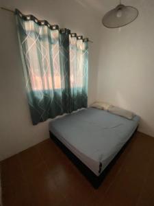 a small bed in a room with a window at Sool Beach Hostel in Bertioga +6 photos