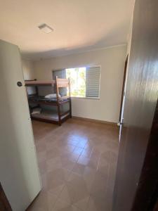an empty room with a room with a refrigerator at Sool Beach Hostel in Bertioga