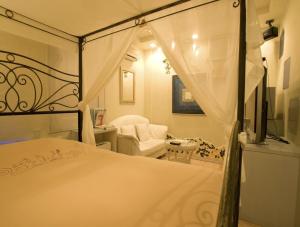 a bedroom with a canopy bed and a chair at ホテルデジャブ大人専用 in Akita