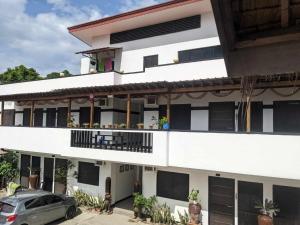 a white building with a car parked in front of it at Anabelle Residence in Dumaguete