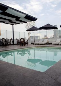 a swimming pool with chairs and umbrellas on a rooftop at Hotel Stella Maris in Mexico City