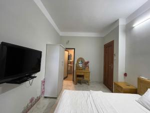 a bedroom with a flat screen tv on the wall at Moc homestay- Near Bai Dai Beach in Cam Lâm