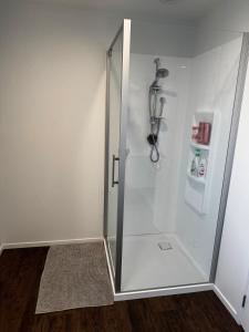 a shower with a glass door in a bathroom at Denbigh Homestay in Midhirst