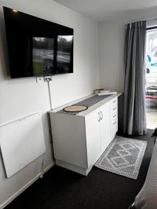 a white kitchen with a counter and a window at Denbigh Homestay in Midhirst