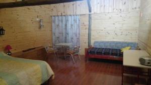 a bedroom with a bed and a table and chairs at Cabañas del Valle in Huerta Grande