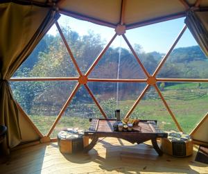 a tent with a table in front of a large window at Mush's rooms in Saint-Julien-Labrousse