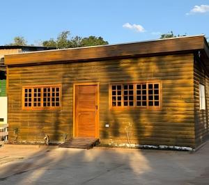 a wooden building with an orange door on it at Katie Studio Prime Hotel Extrema MG + breakfast in Extrema