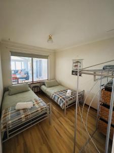 a bedroom with two bunk beds and a window at Bayside Beach Retreat in Safety Bay