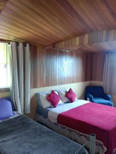 a bedroom with two beds and two blue chairs at Alta Vista in Penedo