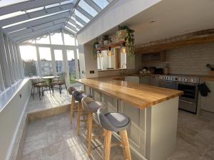 a kitchen with a counter with stools and a table at No2 Back Lane in Thrussington