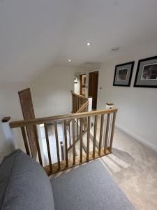 a stairway with a wooden railing in a room at No2 Back Lane in Thrussington