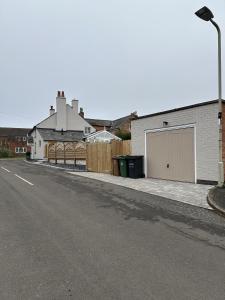 an empty street with a building with a garage at No2 Back Lane in Thrussington