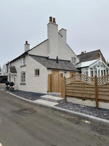 a house with a wooden fence in front of it at No2 Back Lane in Thrussington +27 photos