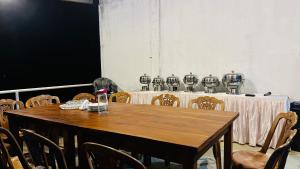 a wooden table with chairs and a table with plates on it at The victoria hill Cottage in Digana
