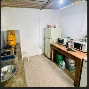 a small kitchen with a refrigerator and a table at The victoria hill Cottage in Digana