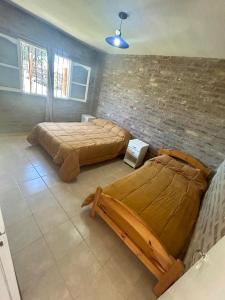 two beds in a room with a brick wall at Los Girasoles in Albardón