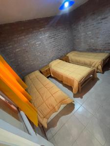 two beds in a room with a brick wall at Los Girasoles in Albardón