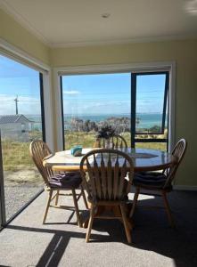 a dining room with a table and chairs and a window at Bluff View in Ocean Beach +5 photos