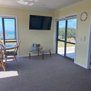 a living room with a table and a tv on the wall at Bluff View in Ocean Beach