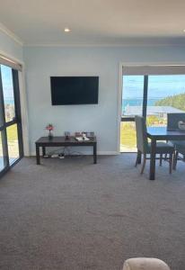 a living room with a table and a television at Bluff View in Ocean Beach