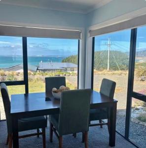 a dining room table and chairs with a view of the ocean at Bluff View in Ocean Beach