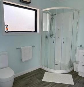 a bathroom with a shower and a toilet and a window at Bluff View in Ocean Beach