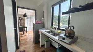 a kitchen with a sink with a tea kettle on it at Anabelle Residence in Dumaguete