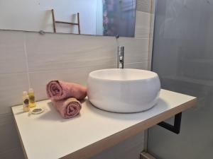 a white sink sitting on a counter in a bathroom at Bella - Destination Guyane in Rémire-Camp